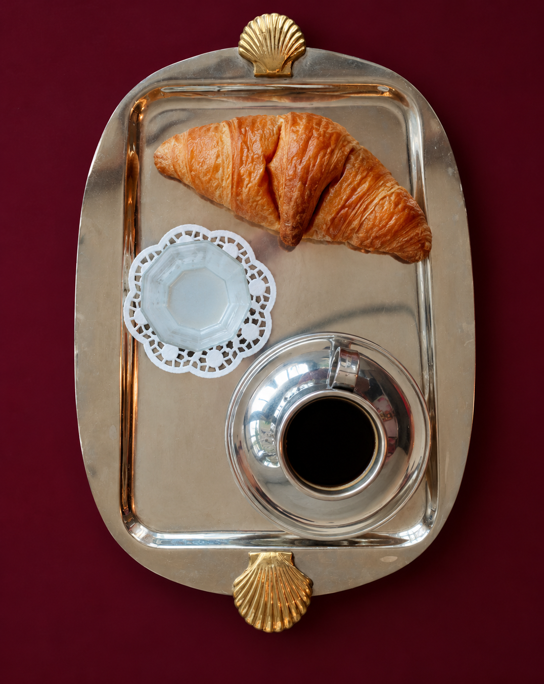 Silver tray with croissant and coffee