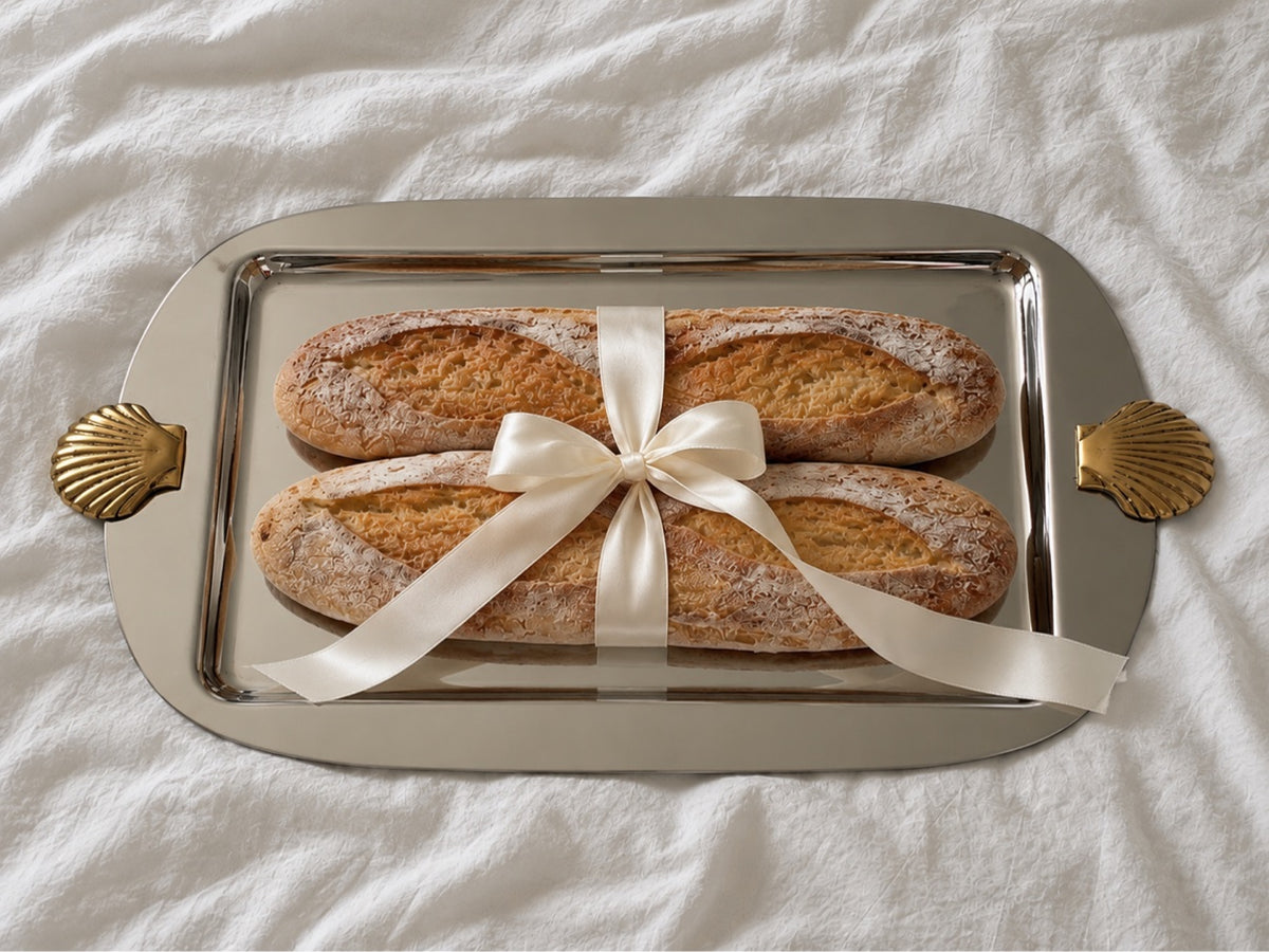 Silver serving tray with ribbon-tied baguettes
