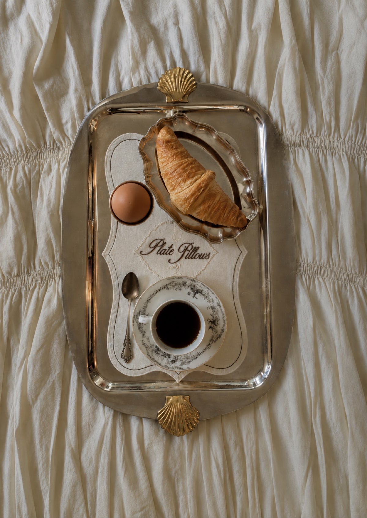Silver serving tray with croissant and coffee, portrait